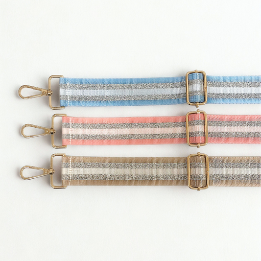 Adjustable banded bag strap in pastel metallic-striped webbing with silver and neutral stripes and gold-tone clasps and sliders