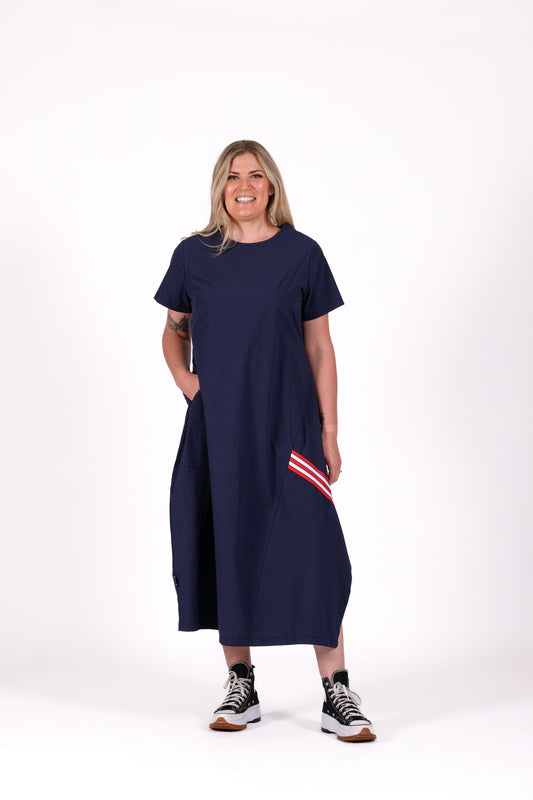 Navy cotton dress with relaxed cocoon shape, angled seams and inset pockets, worn by a model