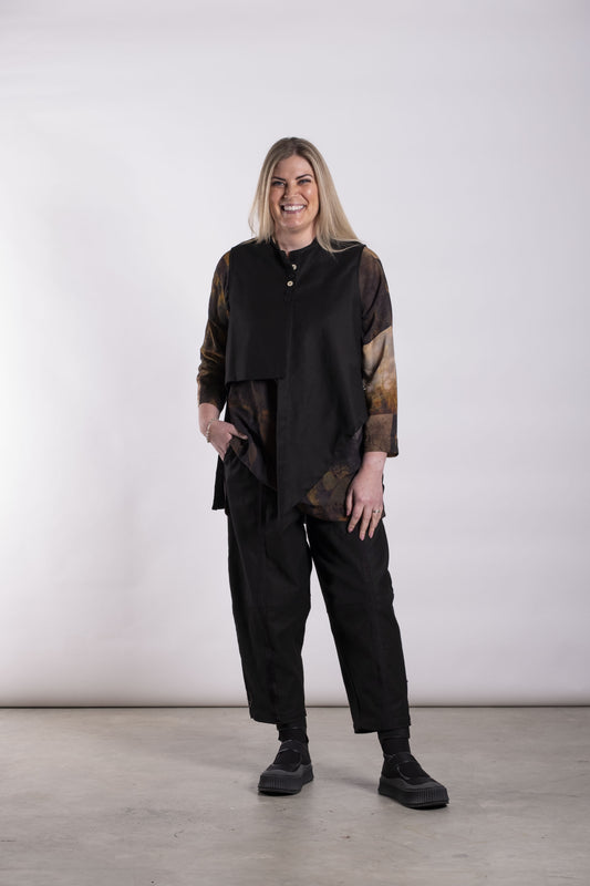 Sleeveless structured vest with button detail on the upper front, an open front and an asymmetrical hem that drops longer at the front