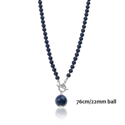Long navy glass bead necklace with a larger bead drop and a silver ring and toggle closure at the front