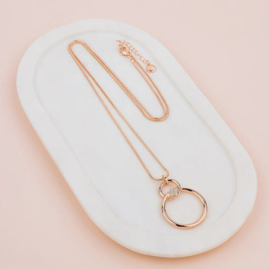 Rose gold pendant necklace with sparkling crystal embellishments on a long chain