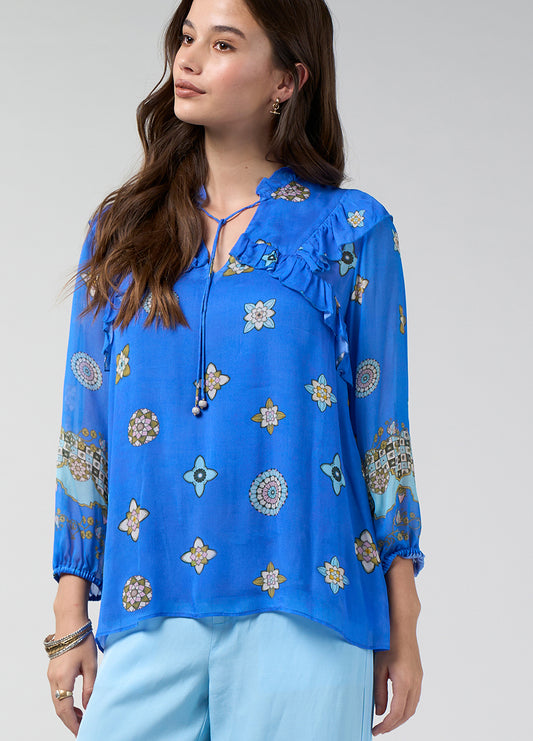 Azure Multi printed blouse with blouson sleeves, elastic cuffs, front ruffles and a small ruffled neckline with a glass bead tie