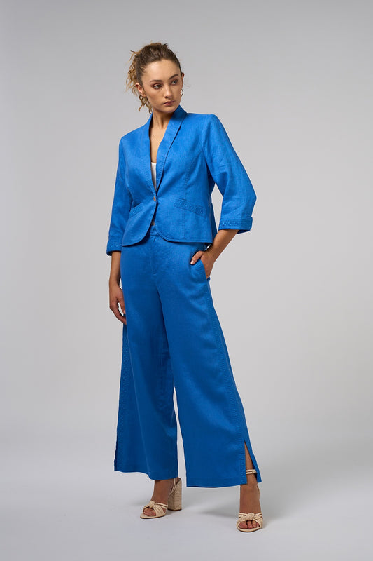 Short linen jacket with shawl collar, cutaway front hemline, back peplum and embroidered pockets and cuffs