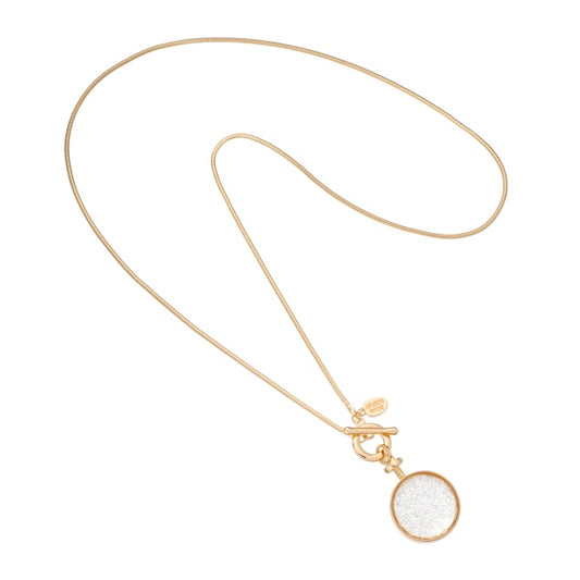 Long necklace with a round pendant disc filled with sparkling crystals, hanging from a fine chain with a fob closure