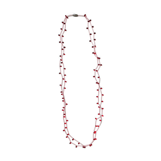 Long double-strand necklace of small red beads on a pale pink clear PVC cord, shown laid out