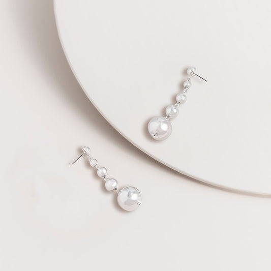 Pair of long silver multi ball drop earrings with graduated metal balls hanging in a slim column