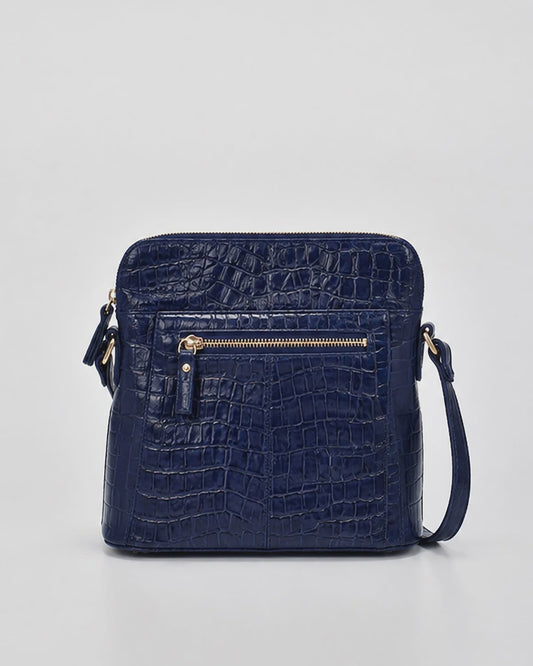 Small croc-embossed leather crossbody bag with gold hardware, top zip and adjustable strap, shown in navy and chocolate