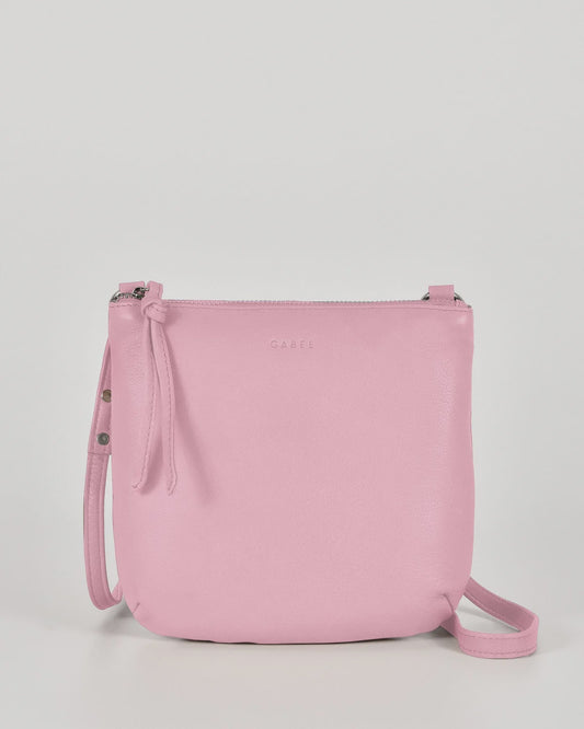 Pink leather Gabee Meadow pouch crossbody bag with studded buckle strap, circular rings and a top zip
