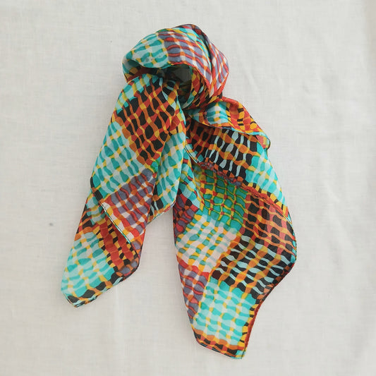 Square silk scarf with flowing lines and a vibrant pattern from Cinnamon Creations, shown laid out flat