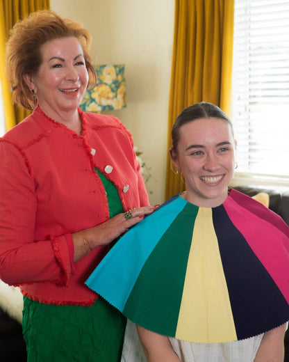 Debbie smiling with a client wearing a rainbow of colour drapes during a Colours Plus session