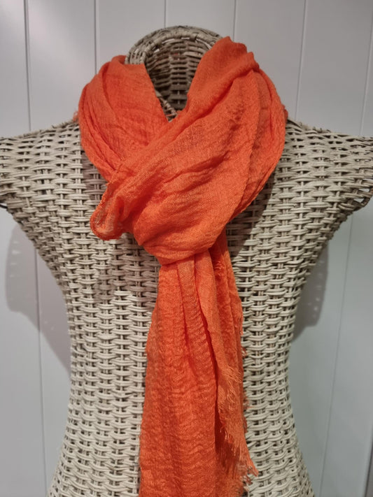 Raw edge viscose scarf in a soft solid colour, draped to show its gentle folds and unfinished edges