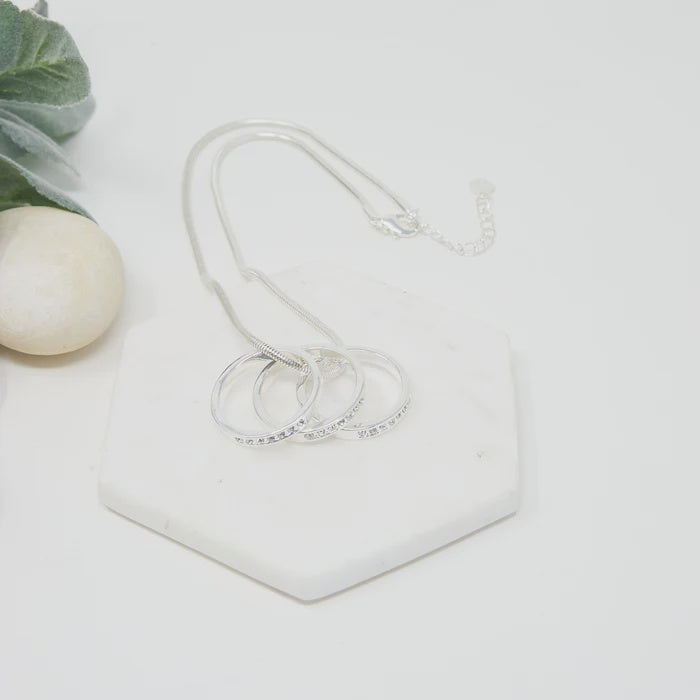 Short silver necklace with a ball chain and a small pendant of three interlinked rings