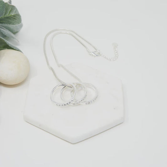 Short silver necklace with a ball chain and a small pendant of three interlinked rings