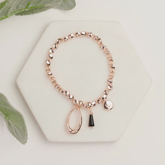 Stretchy rose gold bracelet with black detail, plated over brass, shown as a slim 19cm band