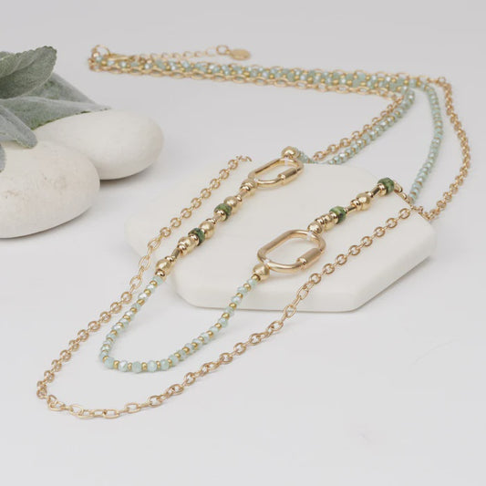 Long gold link chain necklace with pearl and green resin beads, shown with its extension chain